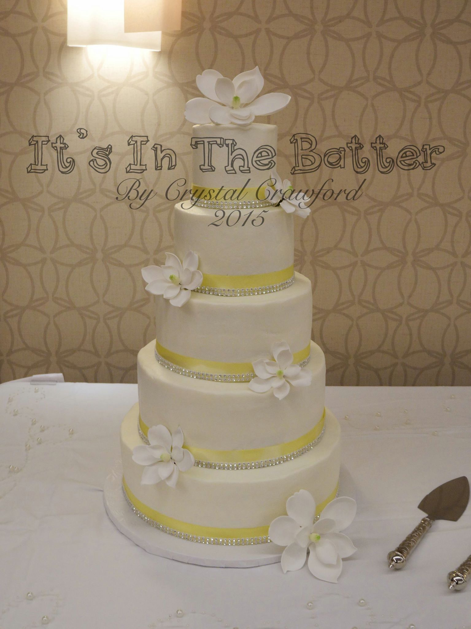 Multi-tiered white buttercream wedding cake with edible sugar magnolia accents
