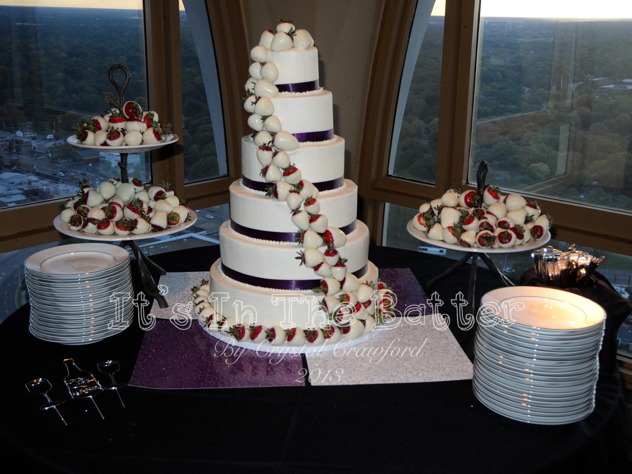 Multi-tiered white buttercream wedding cake with white chocolate covered strawberries